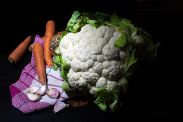 fresh cauliflower with garlic and carrots resting on kitchen napkin. Idea of healthy and country cooking.The concept of environmentally friendly product, healthy nutrition, harvest.