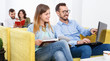 © JackF - Friendly young woman and man relaxing in cozy hostel lobby, spen