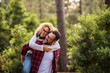 © simona - Happy couple of adult people caucasian man and woman have fun together in outdoor leisure activity in the nature- environment and love or forest concept with playful and youthful hipsters traveler