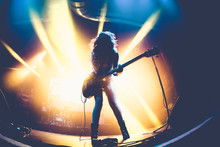 Silhouette Of An Unrecognizable Woman Playing The Electric Guitar