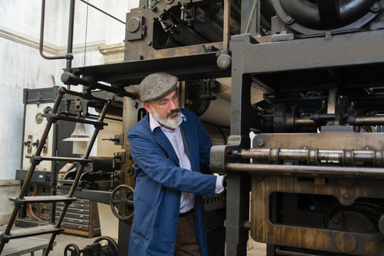 Retro mechanic working on a vintage printing press