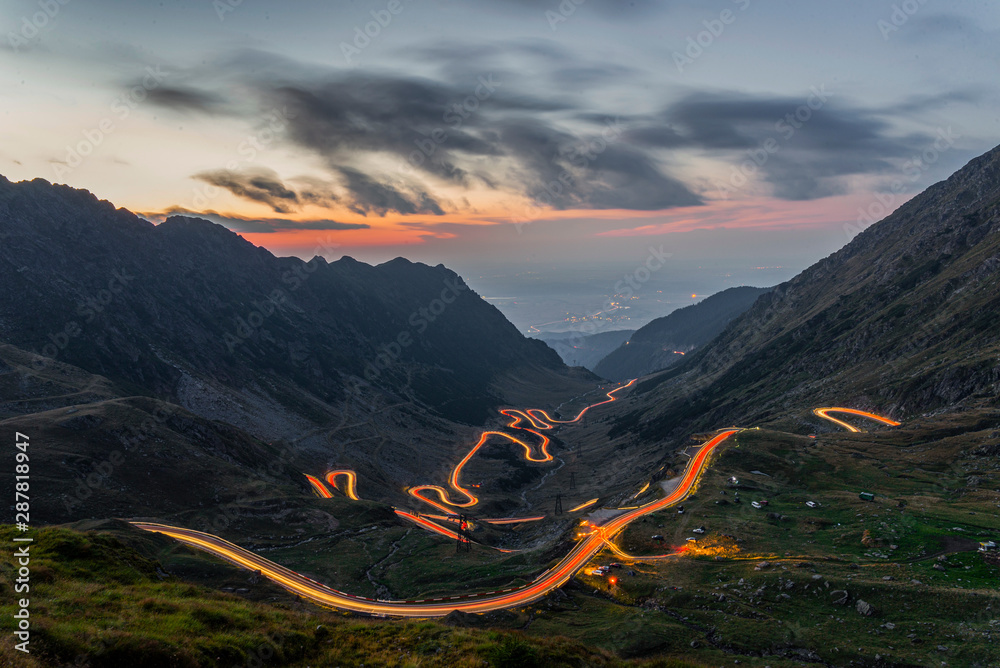 Traffic trails on Transfagarasan pass,crossing Carpathian mountains in Romania, Transfagarasan is one of the most spectacular mountain roads in the world - obrazy, fototapety, plakaty 
