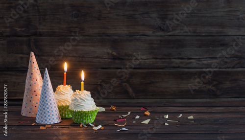 Cuadros en Lienzo birthday cupcakes with candles on old dark wooden background