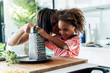 © Westend61 - Happy mother and daughter cooking in kitchen together grating cheese
