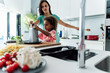 © Westend61 - Mother and daughter cooking in kitchen together grating cheese
