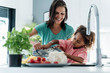 © Westend61 - Happy mother and daughter cooking in kitchen together