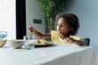 © Westend61 - Girl eating pasta at dining table