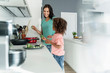 © Westend61 - Mother and daughter cooking in kitchen together