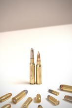 A Couple Of Bullets Standing In Front Of Several Other Bullets Of Various Calibers. It Works As A Concept For Power, Obedience, Domination, Dictatorship.