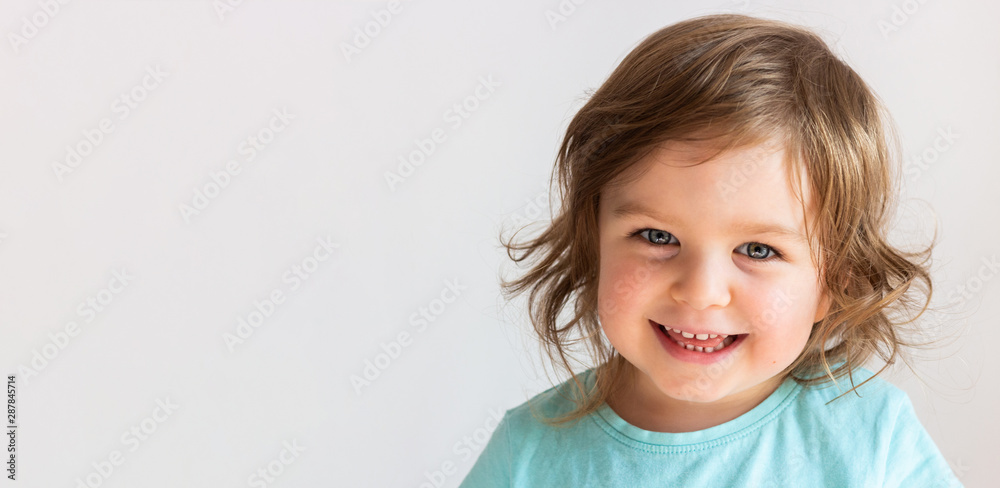 Beautiful happy toddler child girl smiling, portrait neutral background, space for text - obrazy, fototapety, plakaty 