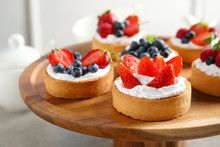 Cake Stand With Different Berry Tarts On Table. Delicious Pastries