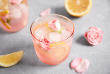 Tasty Refreshing Lemon Drink With Roses On Light Grey Table