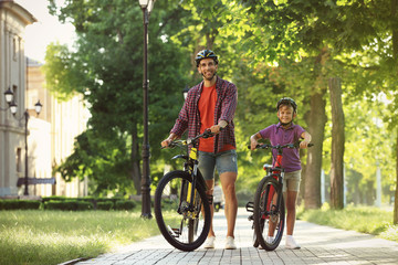 Sticker - Dad and son riding bicycles in park on sunny day