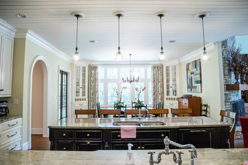 Custom cream kitchen with pendant light and double island with barstool seating