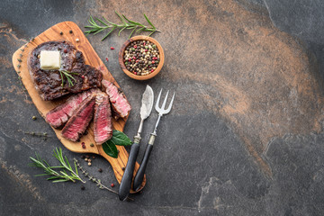 Wall Mural - Medium rare Ribeye steak with herbs and a piece of butter on the wooden tray.