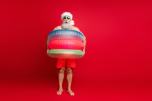 Full Length Body Size View Of Nice Handsome Cheerful Cheery Positive Comic Childish Playful Bearded Gray-haired Man Wearing Air Circles Isolated On Bright Vivid Shine Red Background