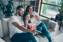 Portrait Of Nice Attractive Lovely Positive Glad Cheerful Cheery Family Wearing Casual White T-shirts Jeans Denim Sitting On Divan Having Fun Watching Video Switching Channel Spending Free Time