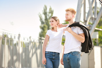 Wall Mural - Man and woman in stylish t-shirts outdoors