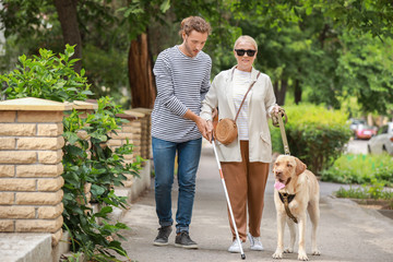 Poster - Blind mature woman with guide dog and son outdoors