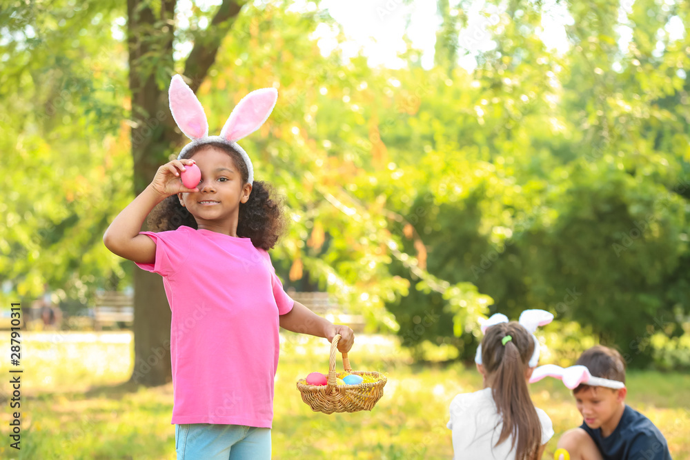 Little children gathering Easter eggs in park