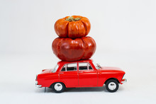 Red Toy Car With Small Pumpkins On The Roof