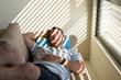 © Esther Pueyo - Relaxed man covered with striped shadow from the blinds, sleeping on a coach.
