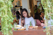 © themorningglory - Asian beautiful women text message on smartphone in coffee bar