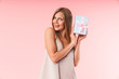 © Drobot Dean - Image of pretty young woman wearing dress smiling and holding gift box