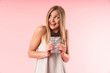 © Drobot Dean - Image of positive blond woman wearing dress looking upward while holding chocolate bar