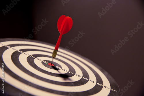Fotomural Red dart arrow hitting in the target center of dartboard on bullseye for Business focus concept