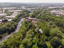 Aerial Footage Of The Made In Leeds Festival Located At The Thwaite Mills Along The Side Of The Leeds Canal Showing The Water And Waterfall On A Sunny Day
