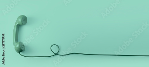 Fotomural A green vintage dial telephone handset with green background.