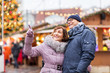 © Syda Productions - travel, tourism, holidays and people concept - happy senior couple hugging at christmas market on town hall square in tallinn, estonia