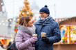 © Syda Productions - love, winter holidays and people concept - happy senior couple with takeaway coffee at christmas market on town hall square in tallinn, estonia