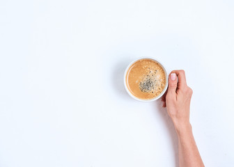 Wall Mural - girl's hand holding coffee cup on white background, flat lay, top view