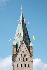 der hohe dom st. maria, st. liborius, st. kilian mit bunten fahnen am kirchturm im sommer vor blauem