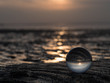Nahaufnahme mit Glaskugel Sonnenuntergang im Wattenmeer bei Cuxhaven