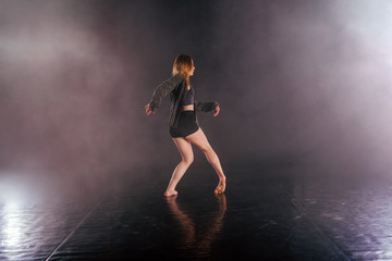 Wall Mural - Shoeless female dance shows off her modern art dance moves while looking serious and devoted.