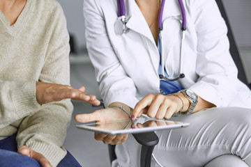 female doctor talking to a patient on a tablet