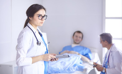 Wall Mural - Doctor checking heart beat of patient in bed with stethoscope