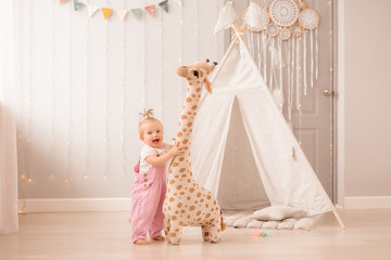 baby girl in the nursery playing,bright children's room, textiles for children's room