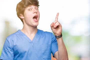 Wall Mural - Young doctor wearing medical uniform over isolated background pointing finger up with successful idea. Exited and happy. Number one.