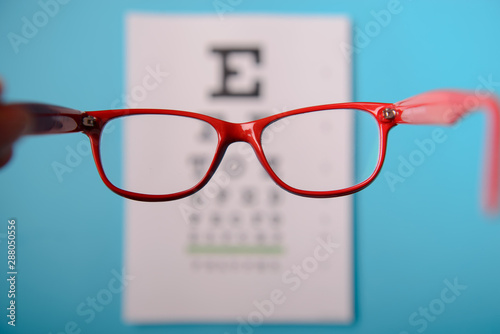 Fotomural glasses lying on snellen test chart