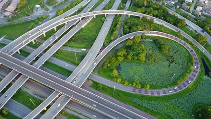 Wall Mural - 4K. Aerial view of road interchange or highway intersection with busy urban traffic speeding on the road. Junction network of transportation taken by drone.