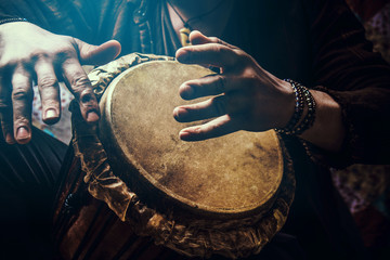 a man playing an ethnic percussion musical instrument jembe. drummer playing african music