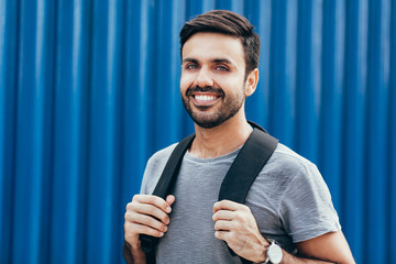 Wall Mural - Outdoor portrait of handsome young male student with backpack