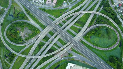 Wall Mural - 4K. Aerial view of road interchange or highway intersection with busy urban traffic speeding on the road. Junction network of transportation taken by drone.