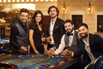 Wall Mural - A group of friends at the casino roulette table.