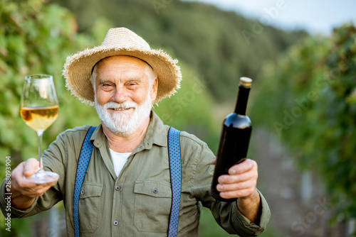 Fotografía Portrait of a happy senior well-dressed winemaker checking wine quality, standin