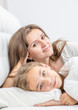 © Ermolaev Alexandr - Happy family at home. Smiling mother lying with her daughter on the bed